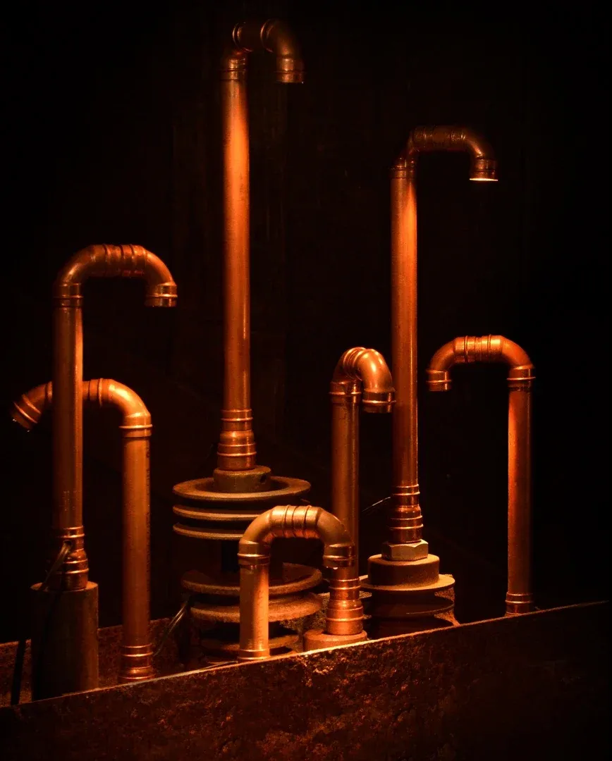 Conjunto de luminárias de cobre apagadas, com bases de aço empilhadas