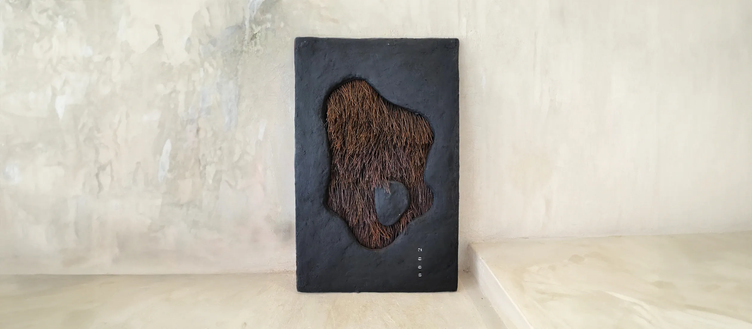Placa escura com fenda de fibra, em nicho de parede clara