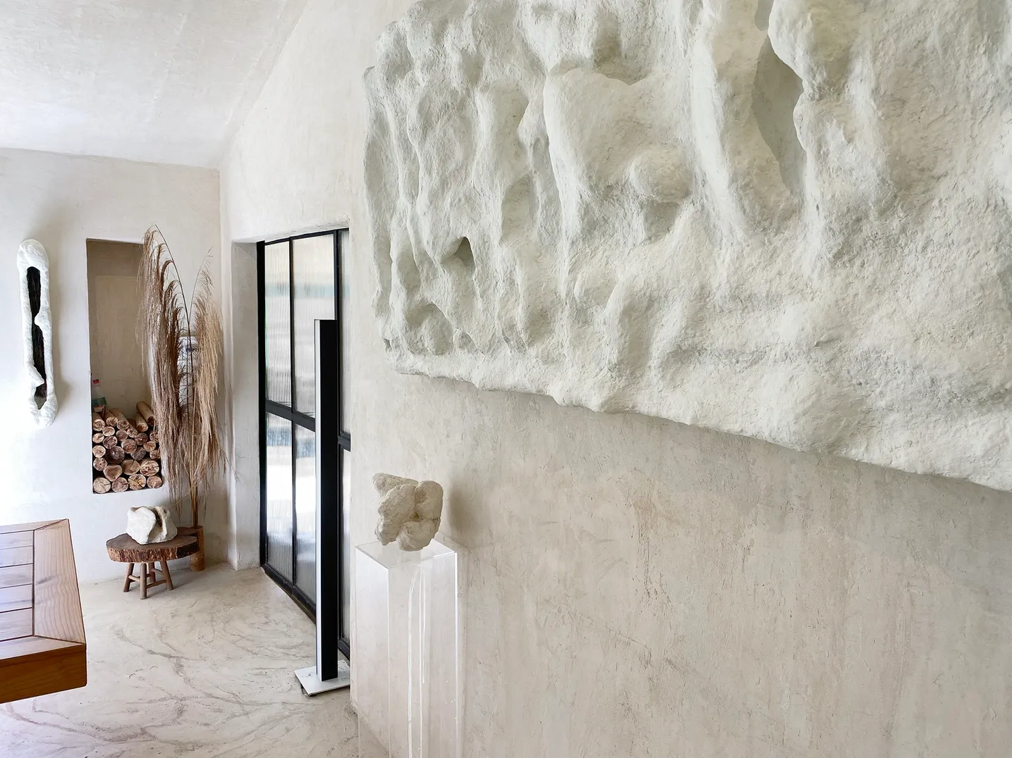 Painel branco em relevo dentro do ambiente, junto à porta